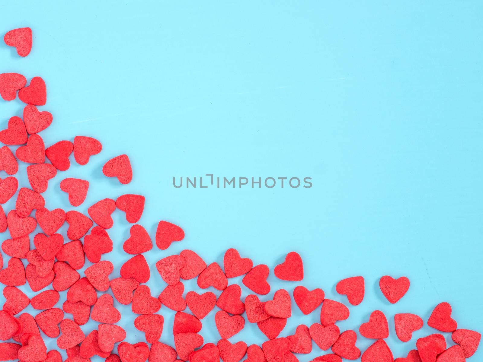 Border frame of red hearth-shape sprinkle on blue background by fascinadora