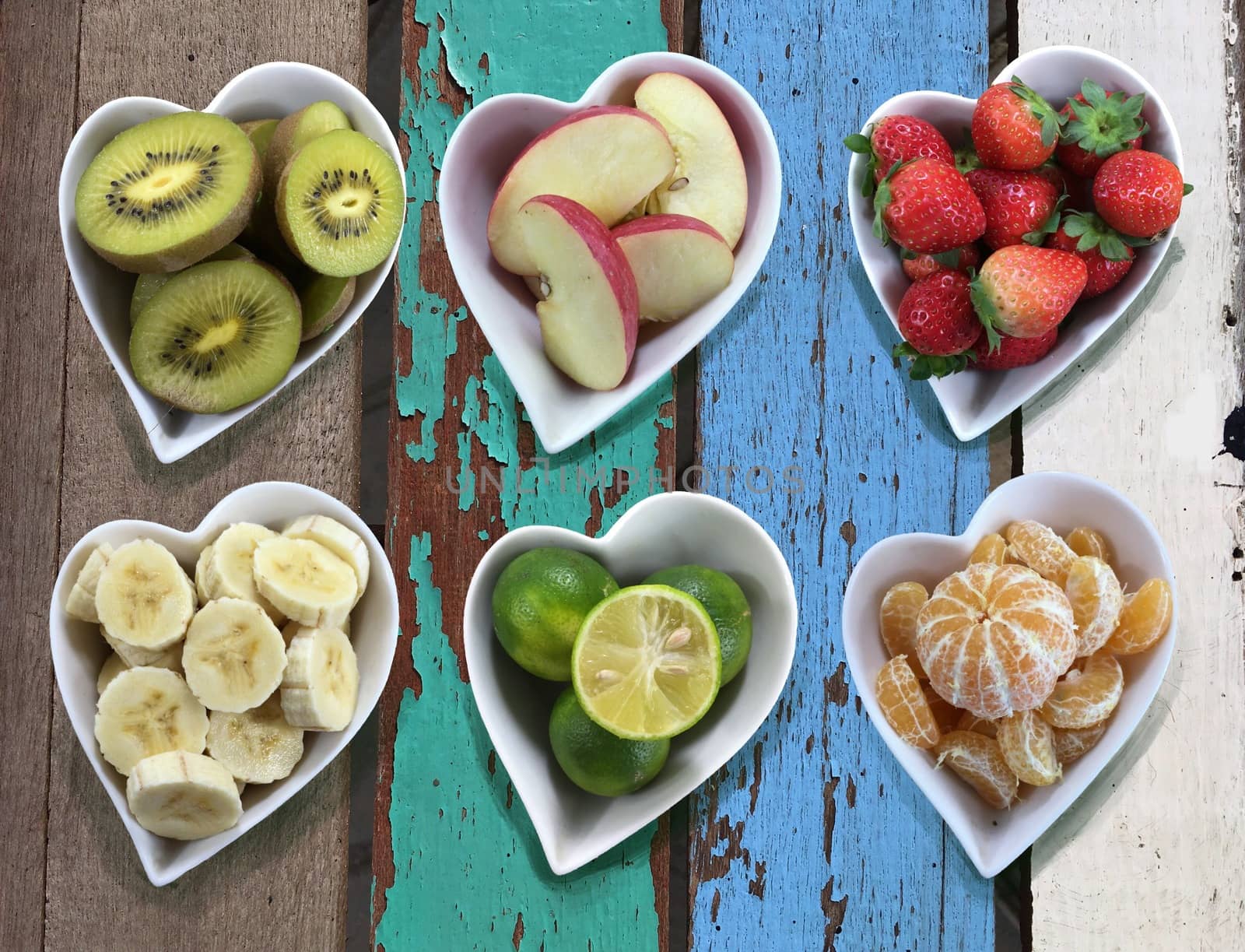 Background of diet food in heart shaped bowls set on old vintage wooden texture.