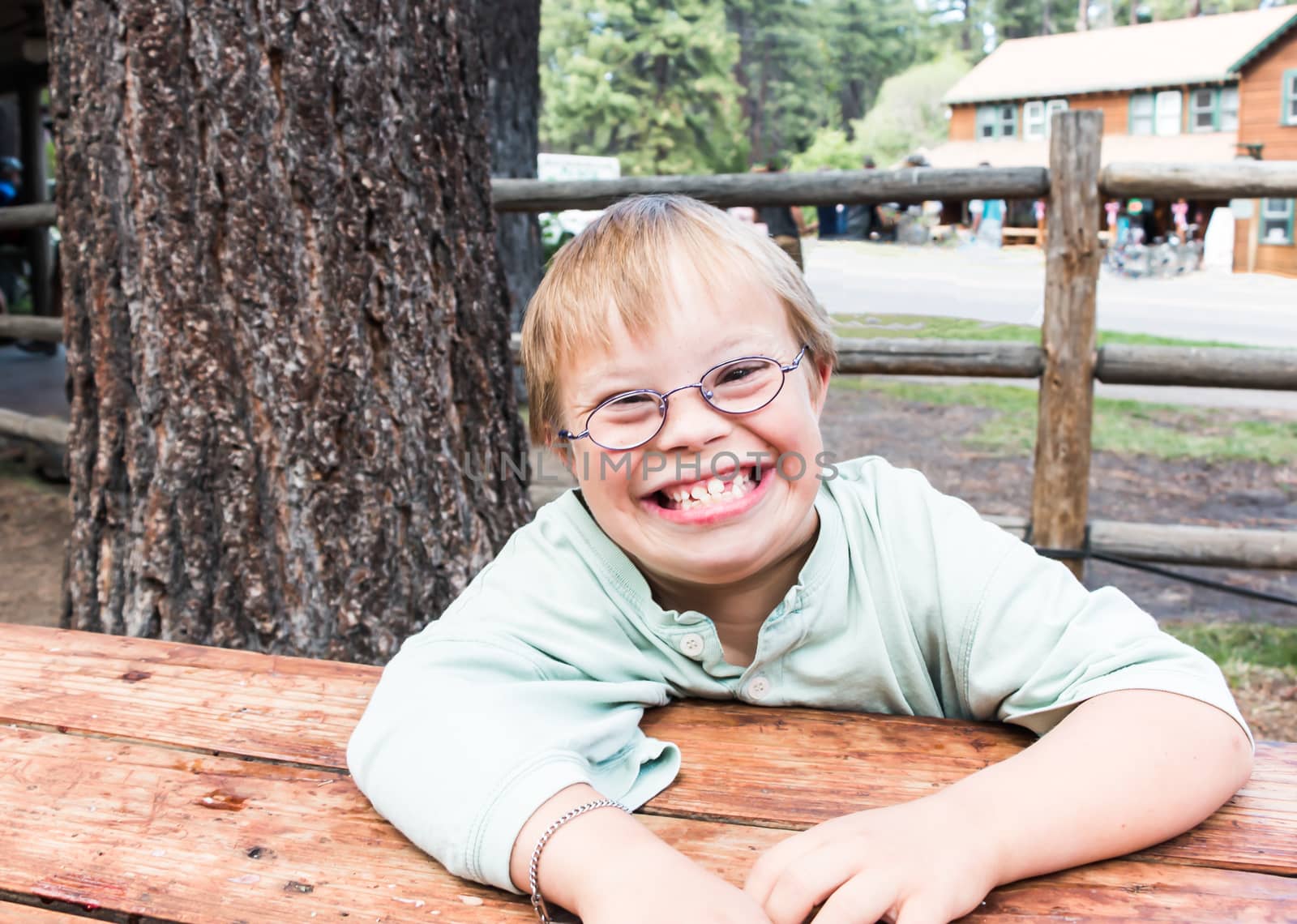 Cut Little Boy With Downs Syndrome Sitting at Table