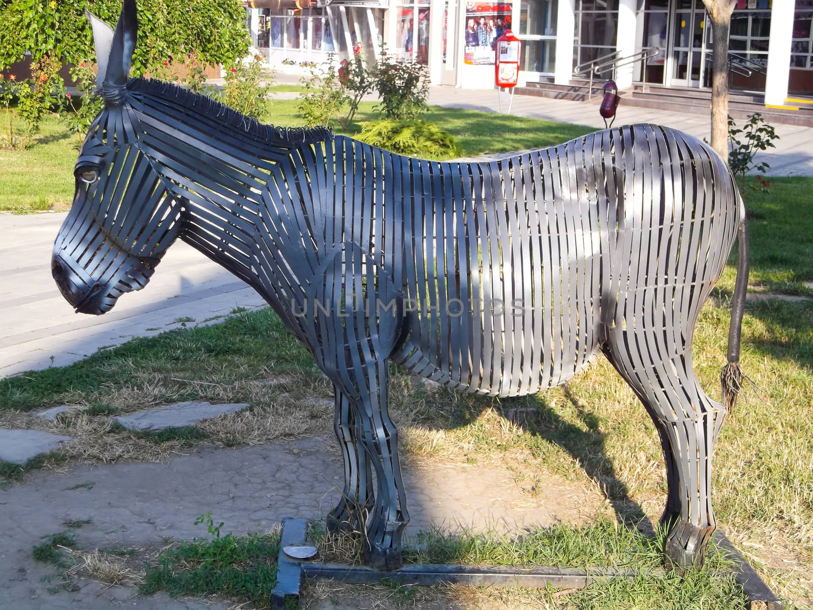 sculpture of a donkey made of metal presented in the open air