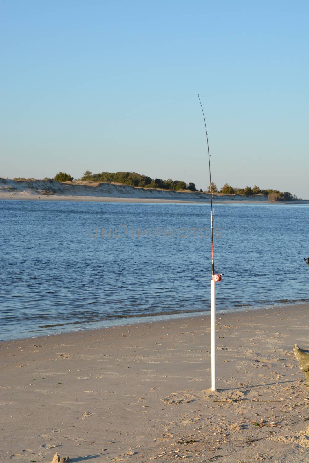 A view of the shore around the north end of Carolina Beach with a fishing pole suck in the ground.