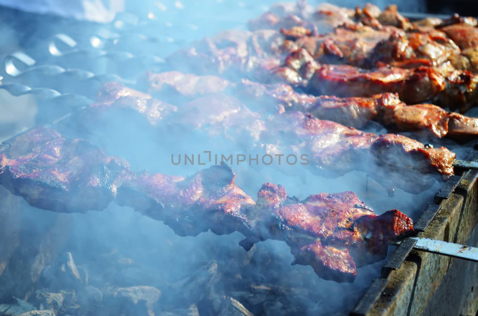 Meat is fried on skewers over charcoal on the grill