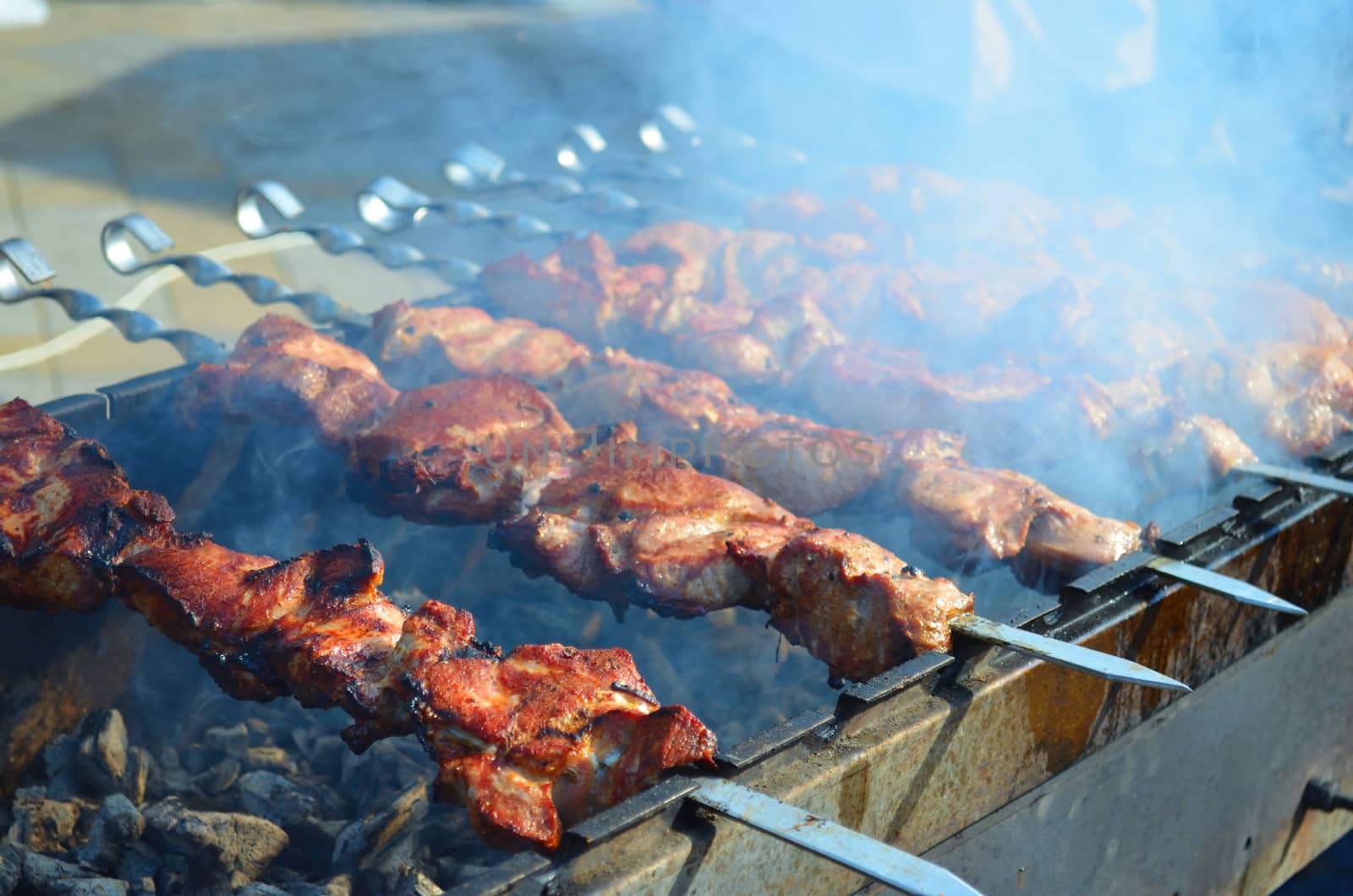 Meat is fried on skewers over charcoal on the grill