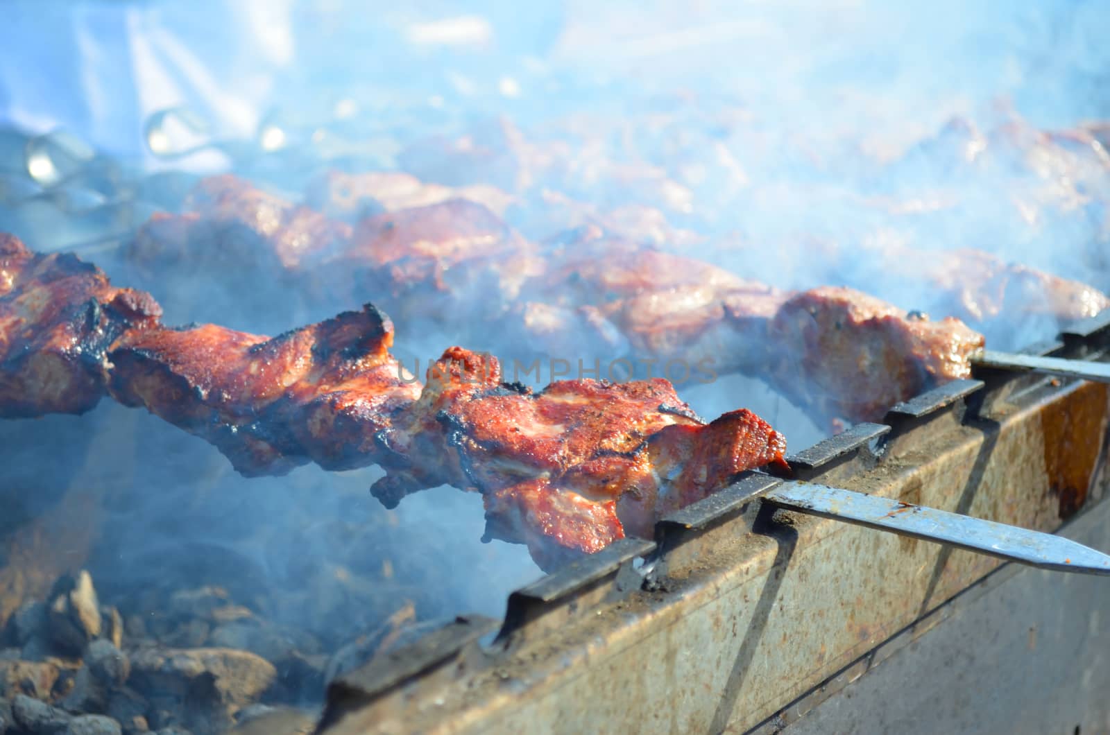 Meat is fried on skewers over charcoal on the grill