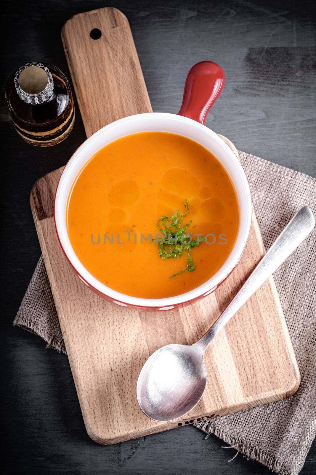 Pumpkin creme soup with a spoon served on a table