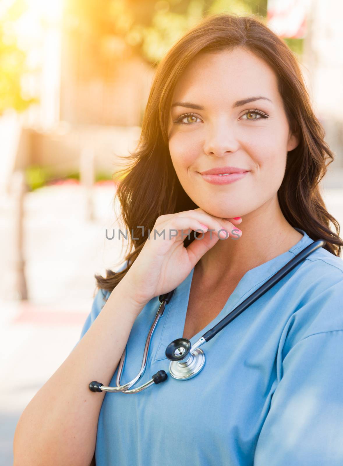 Portrait of Young Adult Female Doctor or Nurse Wearing Scrubs and Stethoscope Outside.