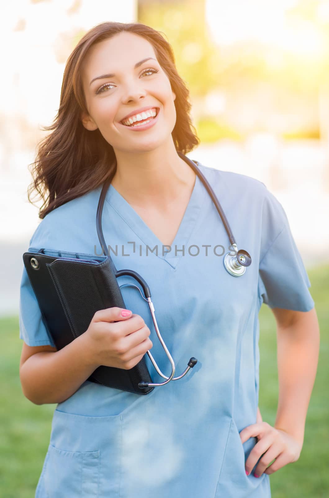 Attractive Young Adult Woman Doctor or Nurse Holding Touch Pad Outside by Feverpitched
