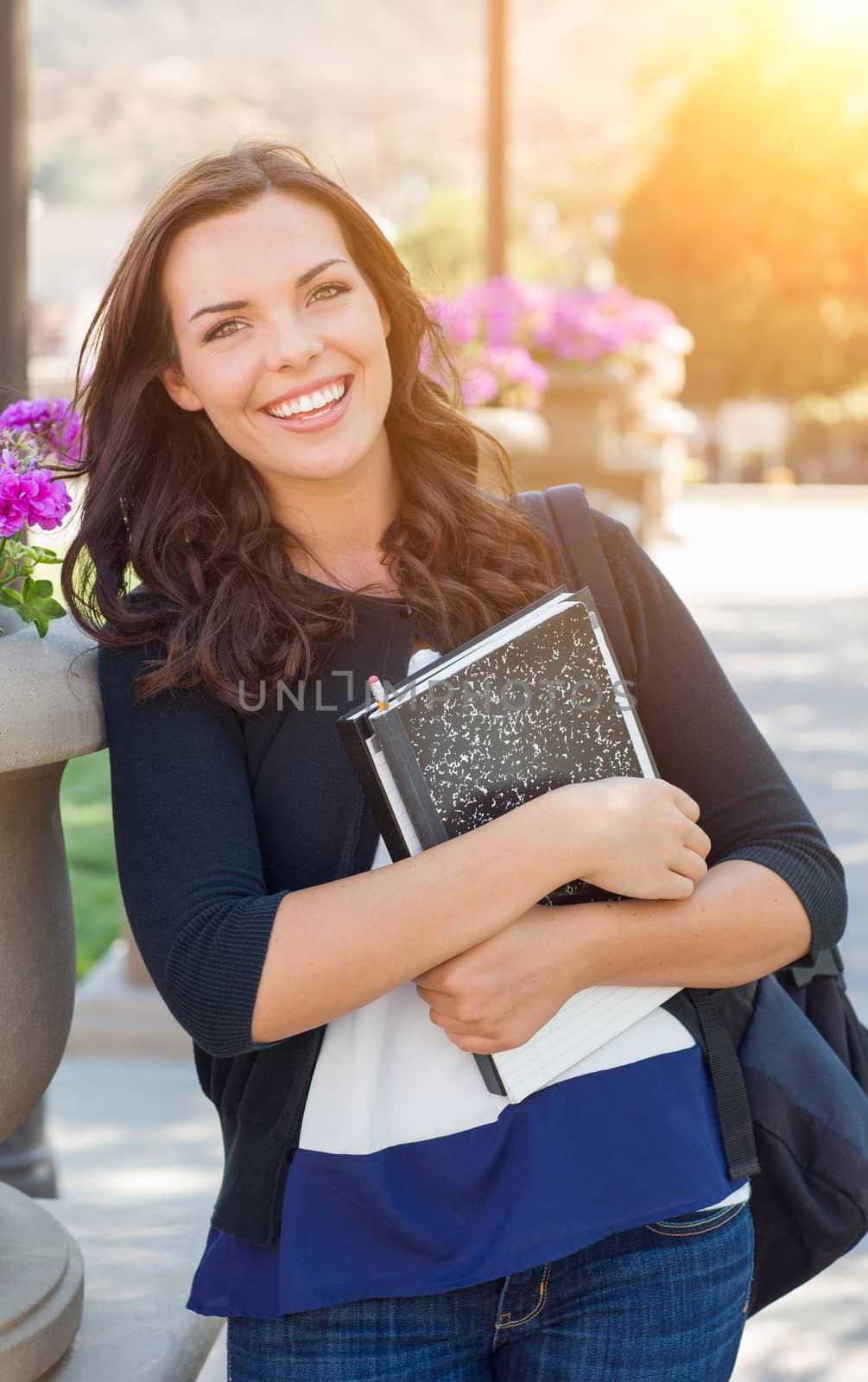 Portrait of Pretty Young Female Student Carrying Books on School Campus by Feverpitched