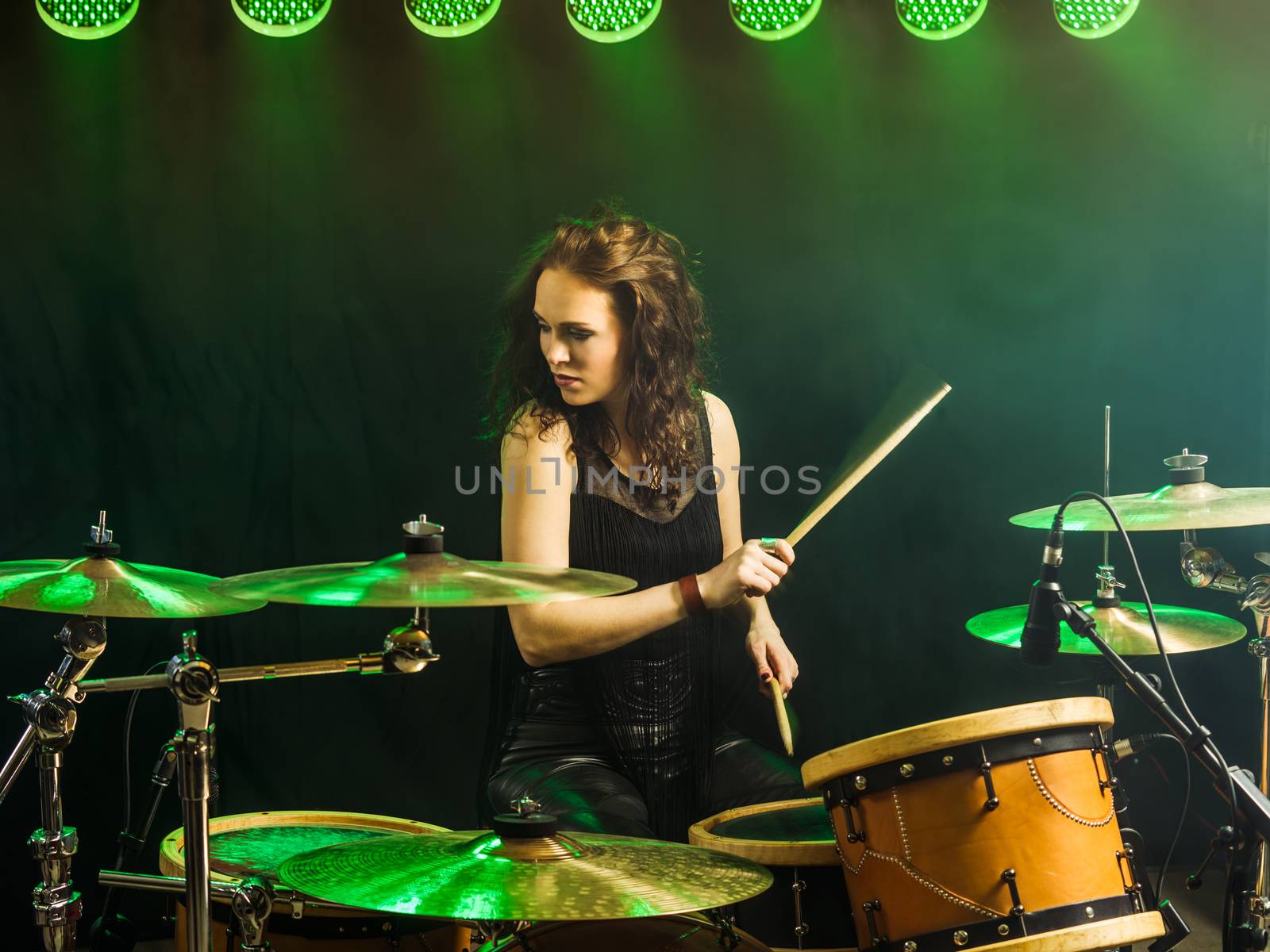 Beautiful woman playing drums onstage by sumners