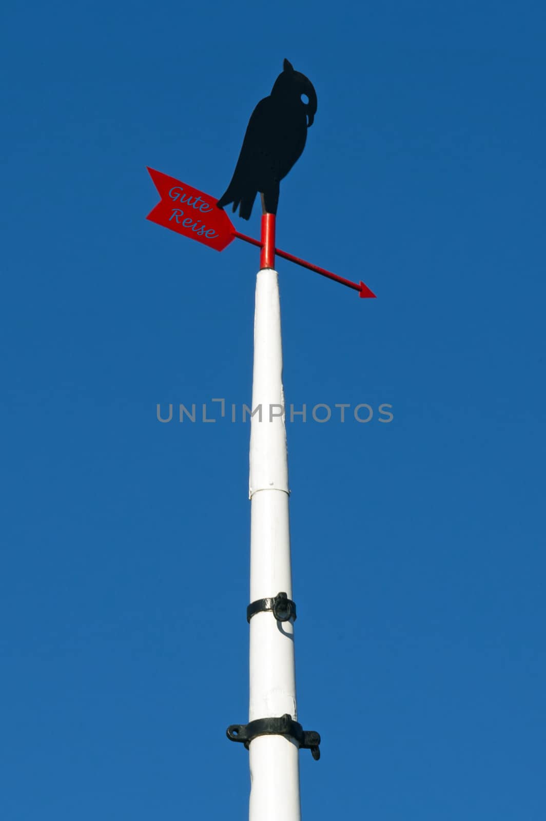 Ship mast with stylized bird and wind flag and the german words for Good Trip