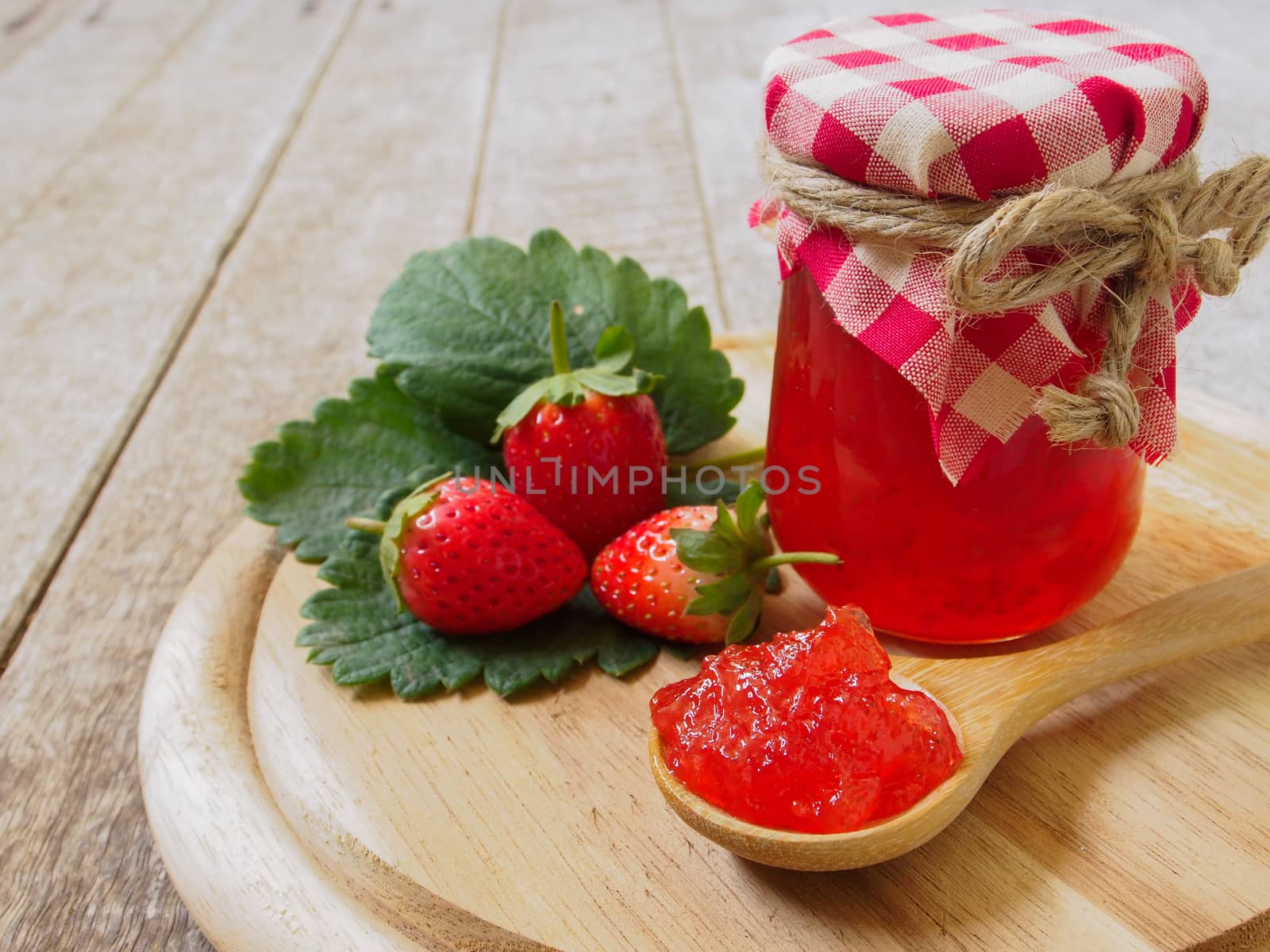 strawberry jam  in a wooden spoon