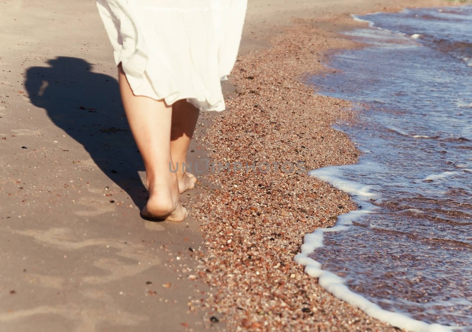 vacation travel - woman leg closeup walking on white sand relaxing in beach cover-up pareo beachwear. Sexy and tanned legs. Sunmmer holidays, weight loss or epilation, pedicure concept.