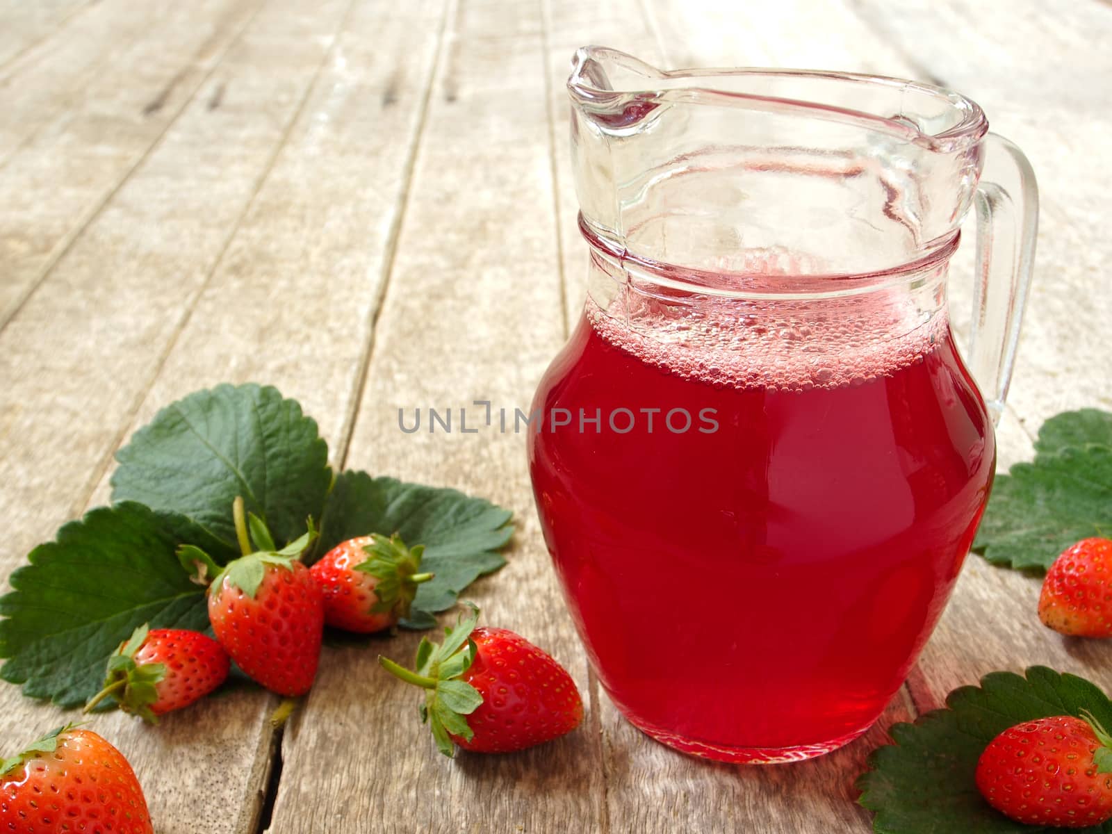 Strawberry Juice In jug on wood background