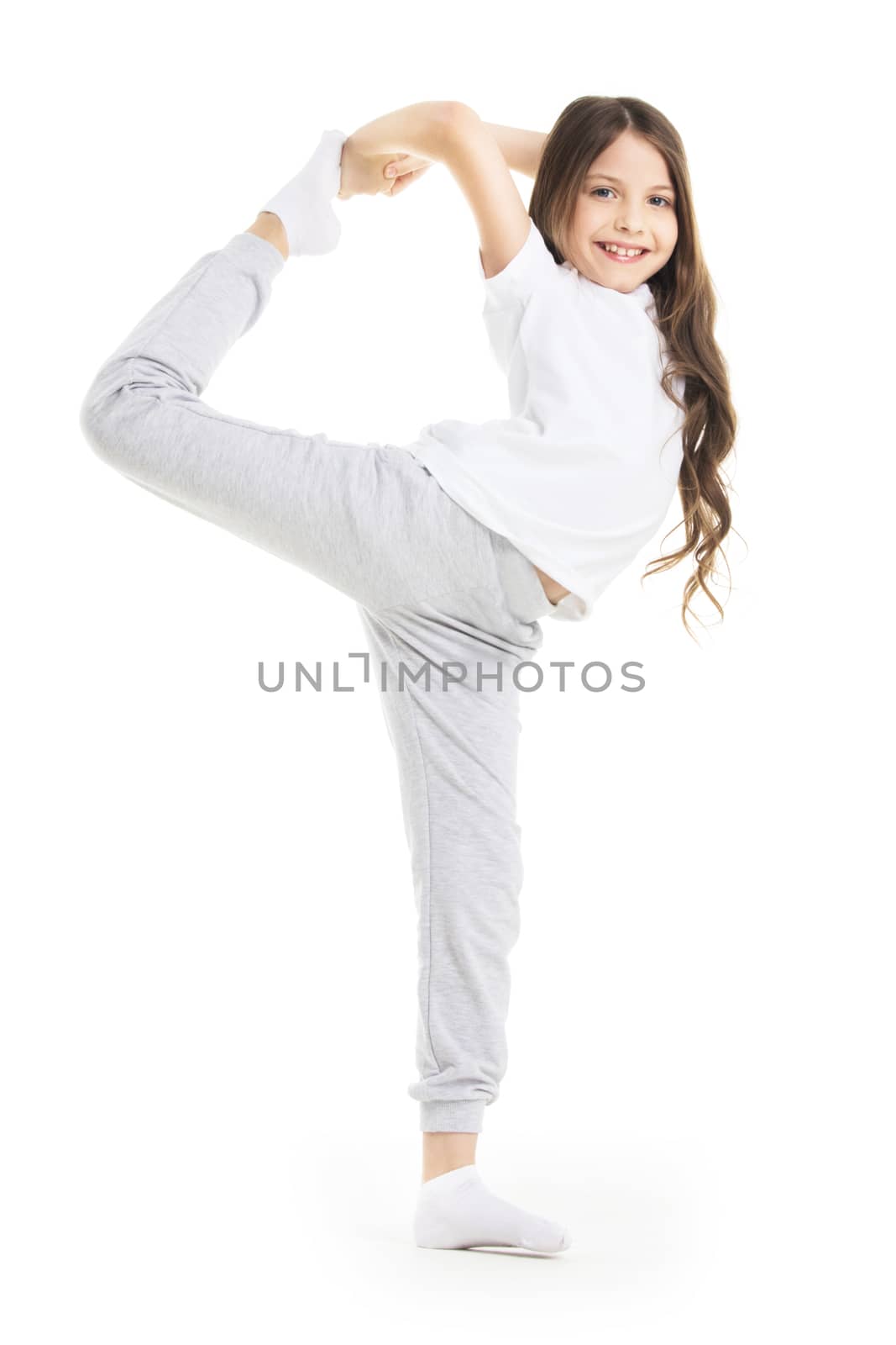 Small girl doing stretching leg exercise isolated on white background