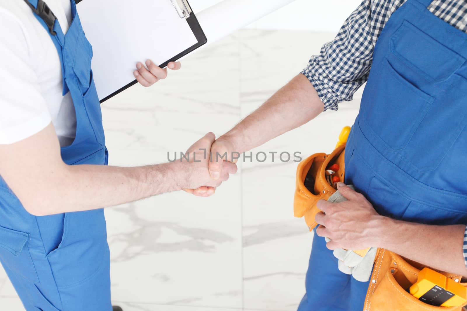 Two construction workers shaking hands, deal is finished concept