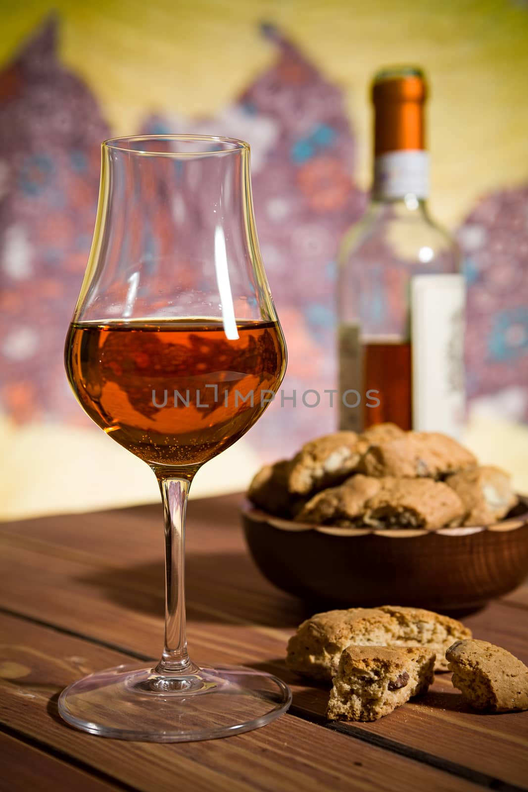 Closeup of a glass of Italian vin santo wine and cantucci biscuits on a wooden table