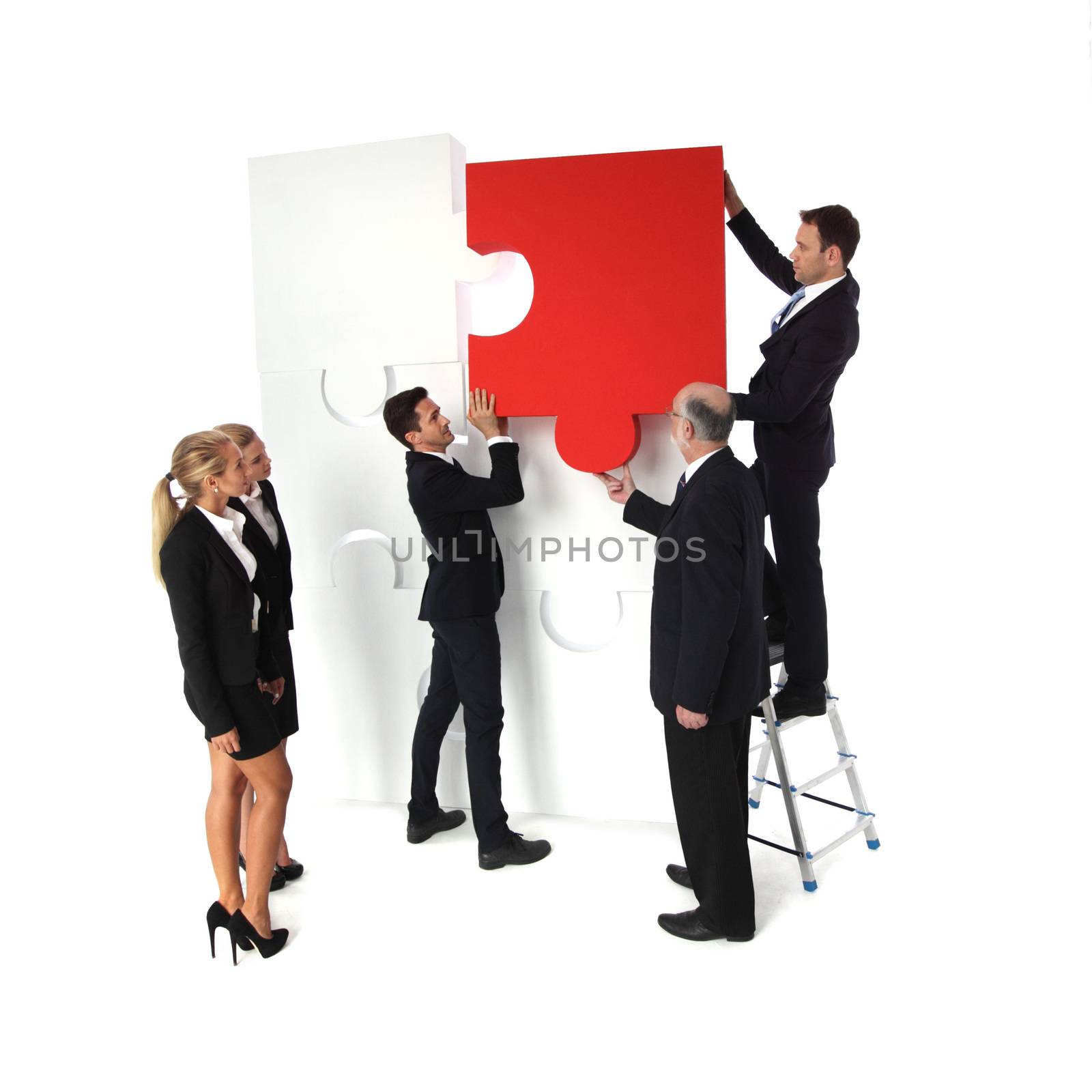 Group of business people assembling jigsaw puzzle isolated on white background