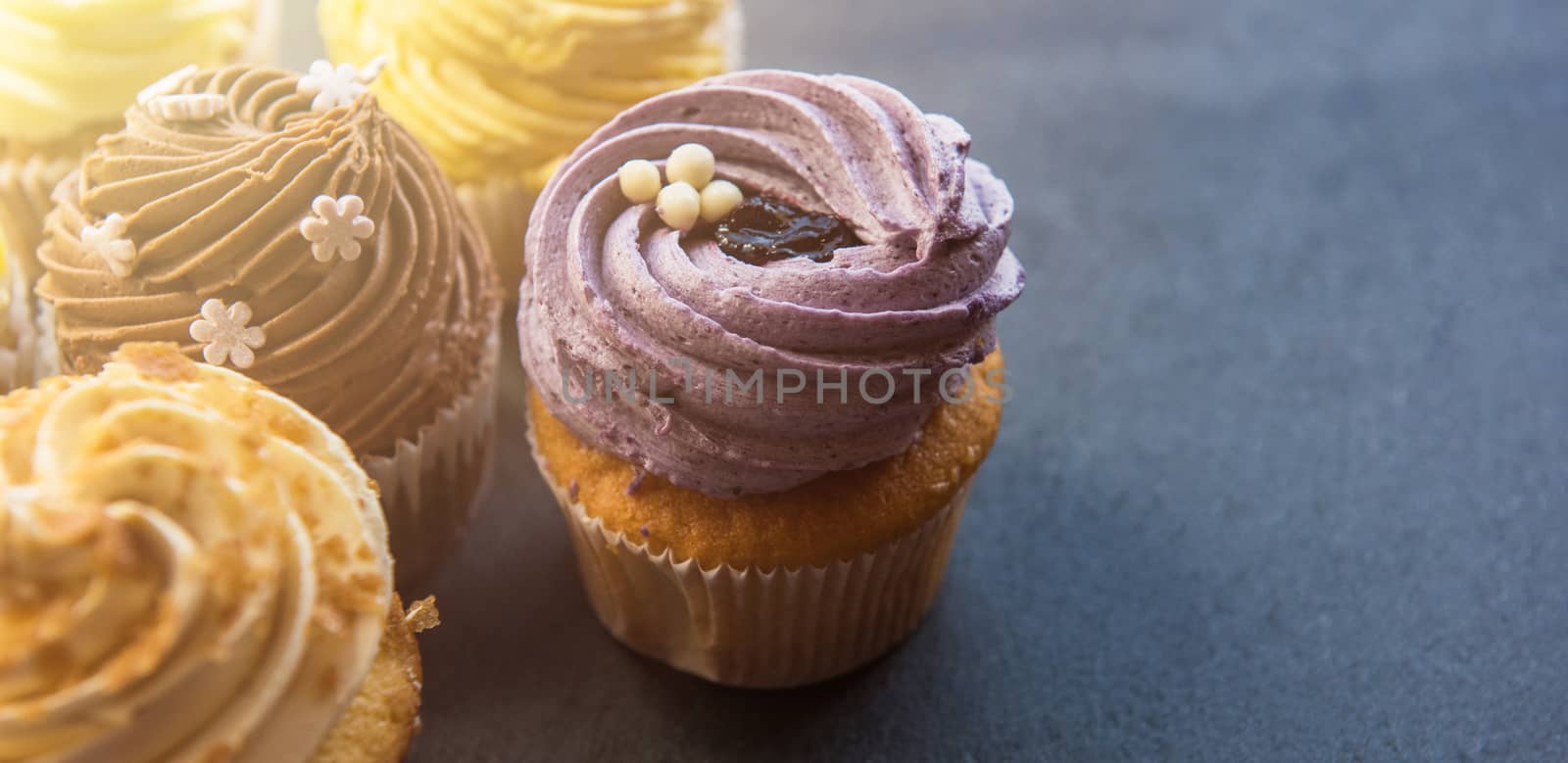 Cupcakes desert cream with space for text on a stone background