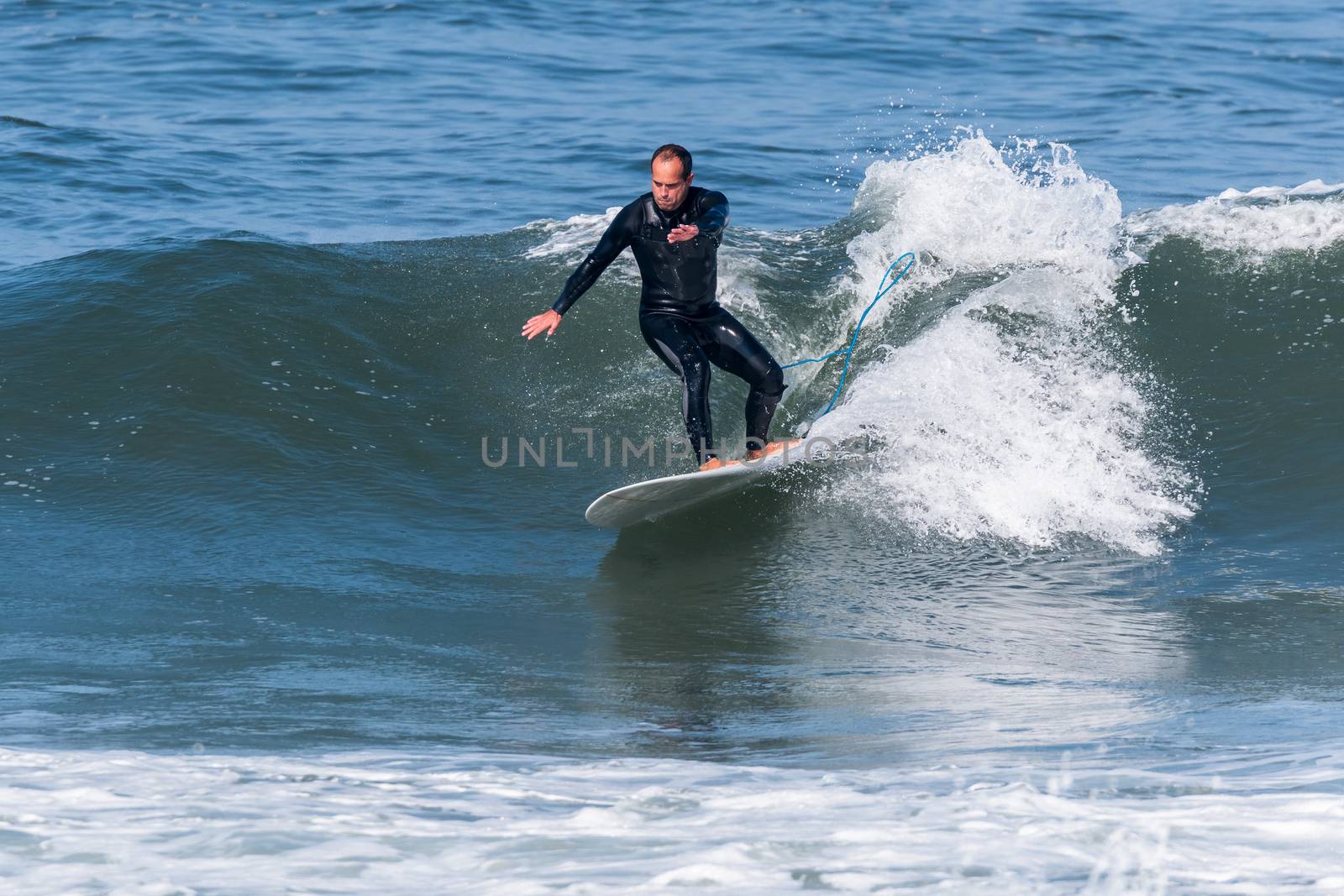 Surfer in action on the ocean waves on a sunny day.