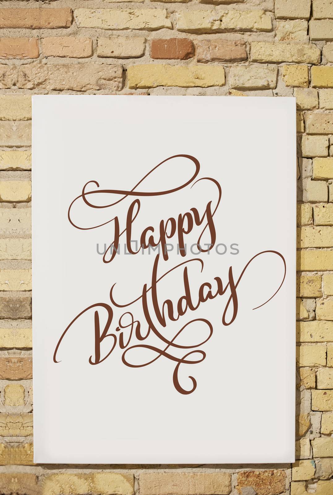 brick wall and white sheet and text Happy Birthday. Calligraphy lettering.