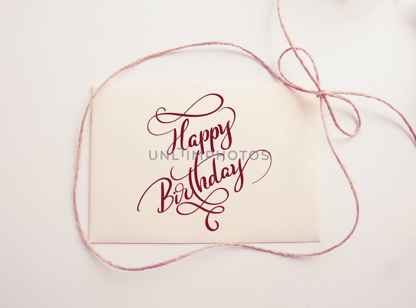 sheet of paper with bow and text Happy Birthday. Calligraphy lettering. Greating card.