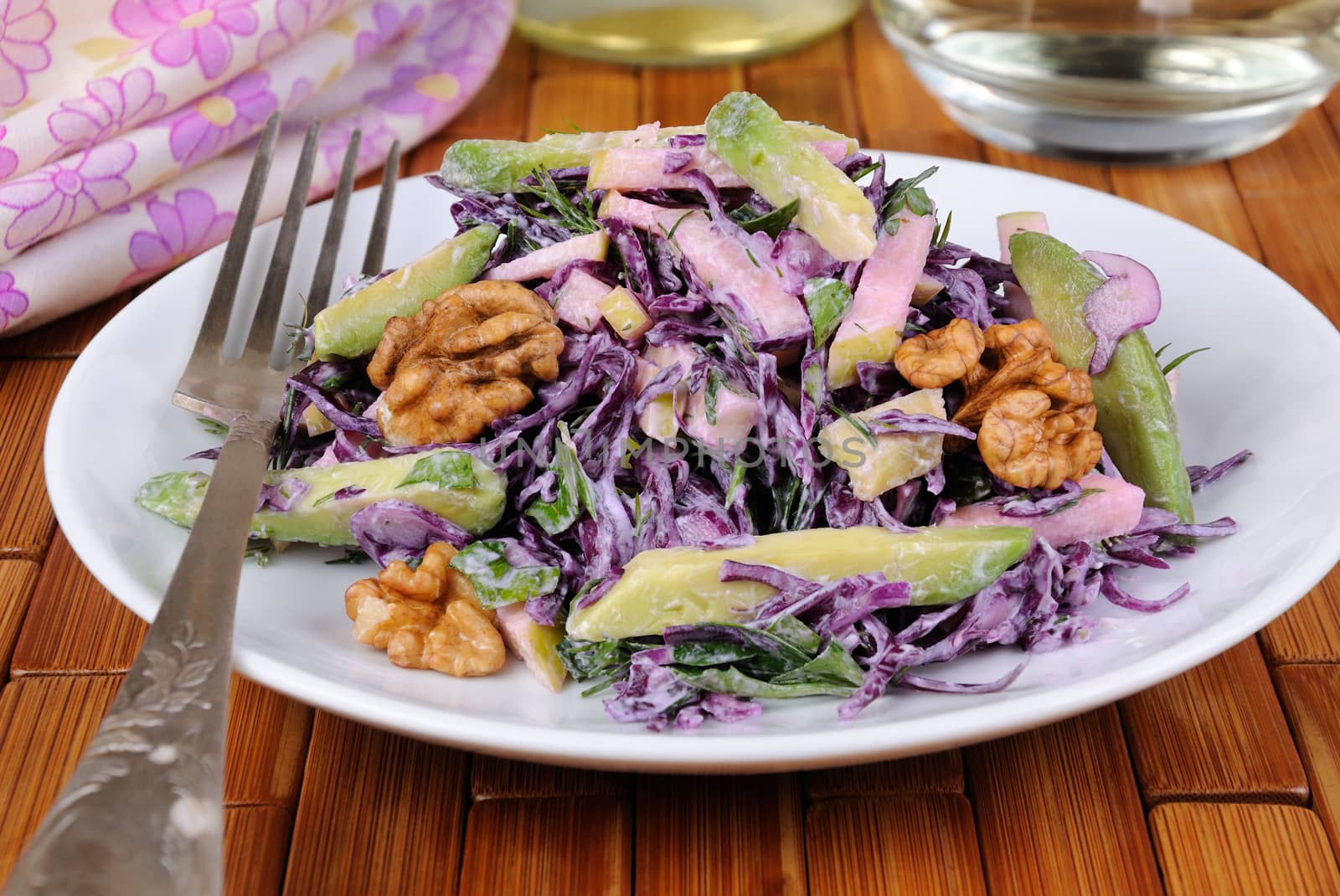 salad  red coleslaw with slices of avocado, apple, nuts, parsley, dill seasoned yoghurt sauce