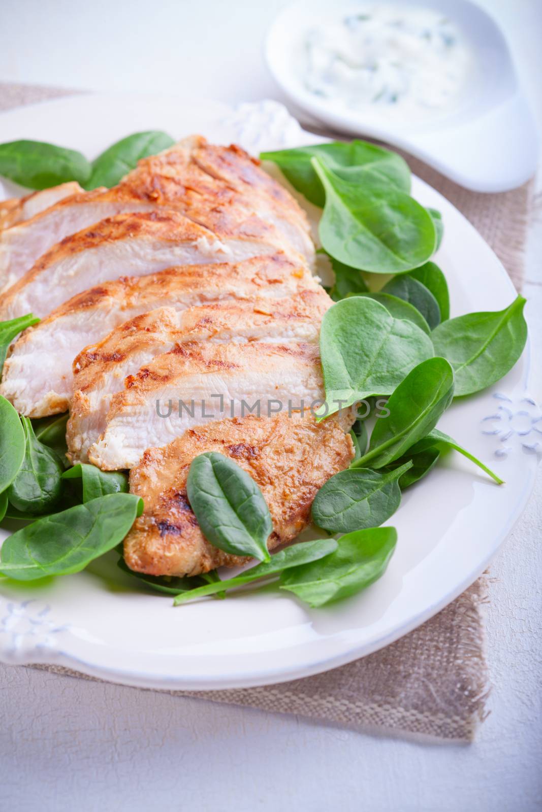 Grilled chicken breast with greenery on a plate