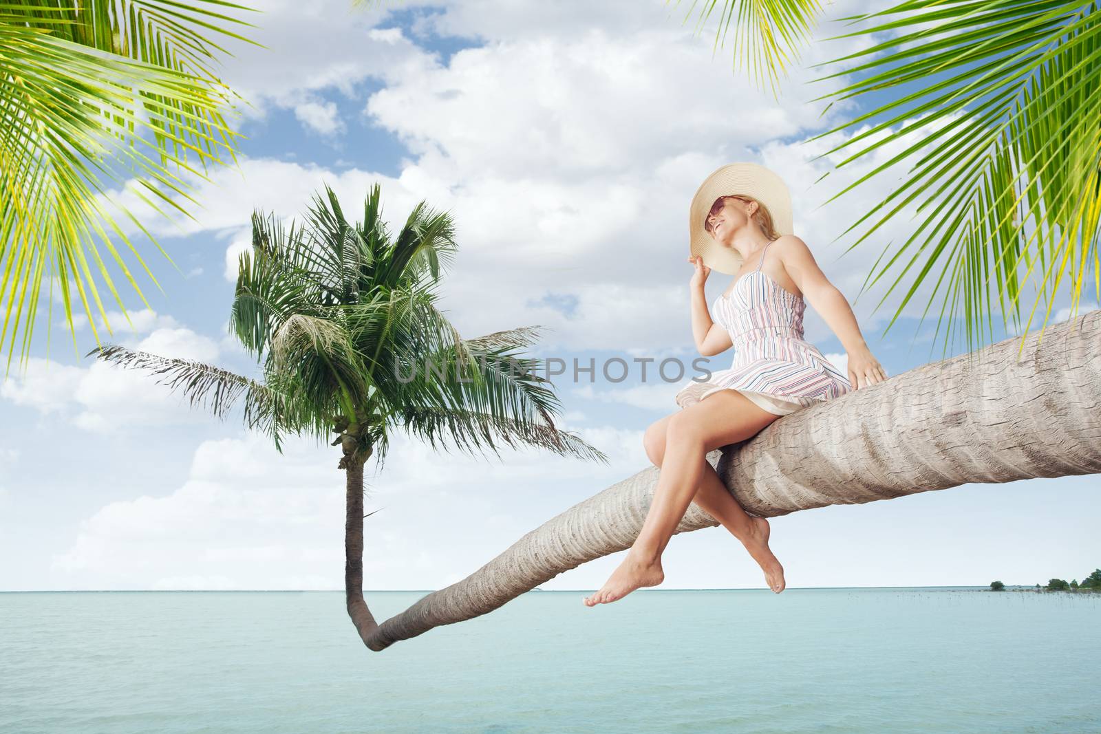 view of nice young lady sitting on palm  on tropical beach.