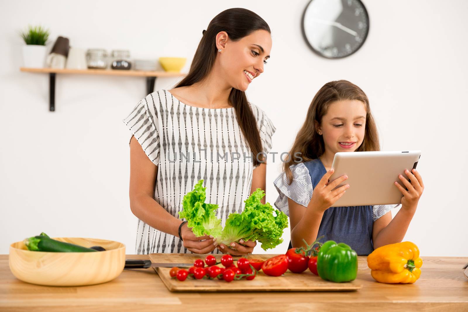 Shot of a mother and daughter having fun in the kitchen