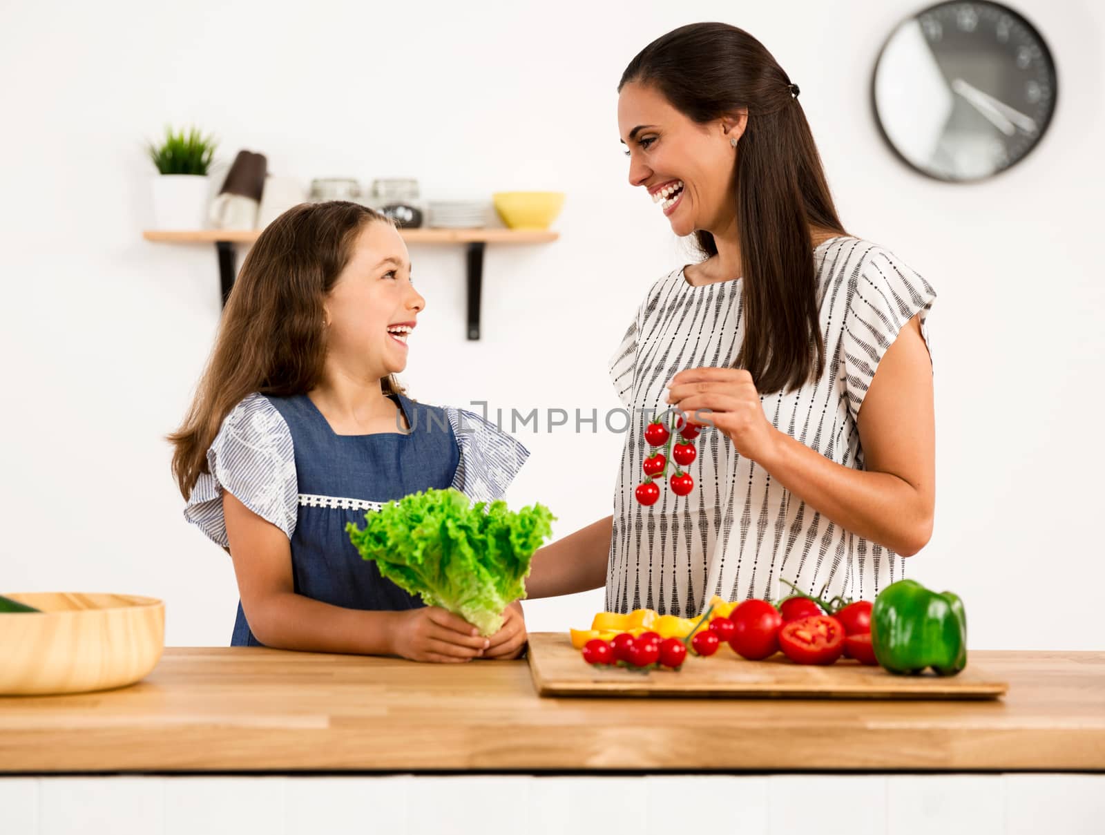 Shot of a mother and daughter having fun in the kitchen