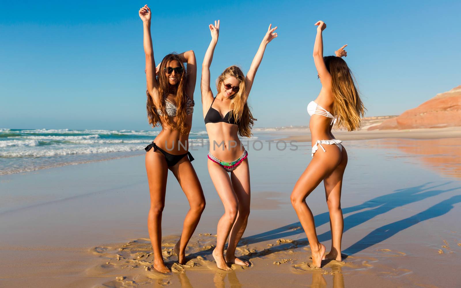 Three beautiful girls having fun on the beach