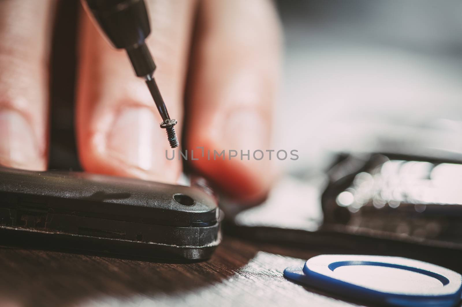 Close-up of a male hands servising broken smartphone.