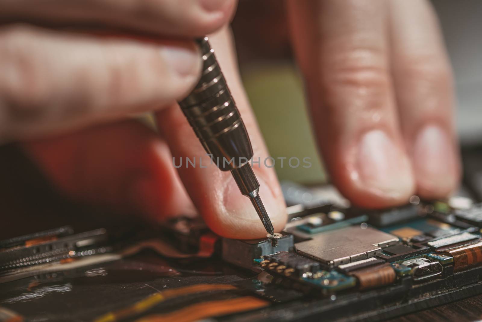 Close-up of a male hands servising broken smartphone.