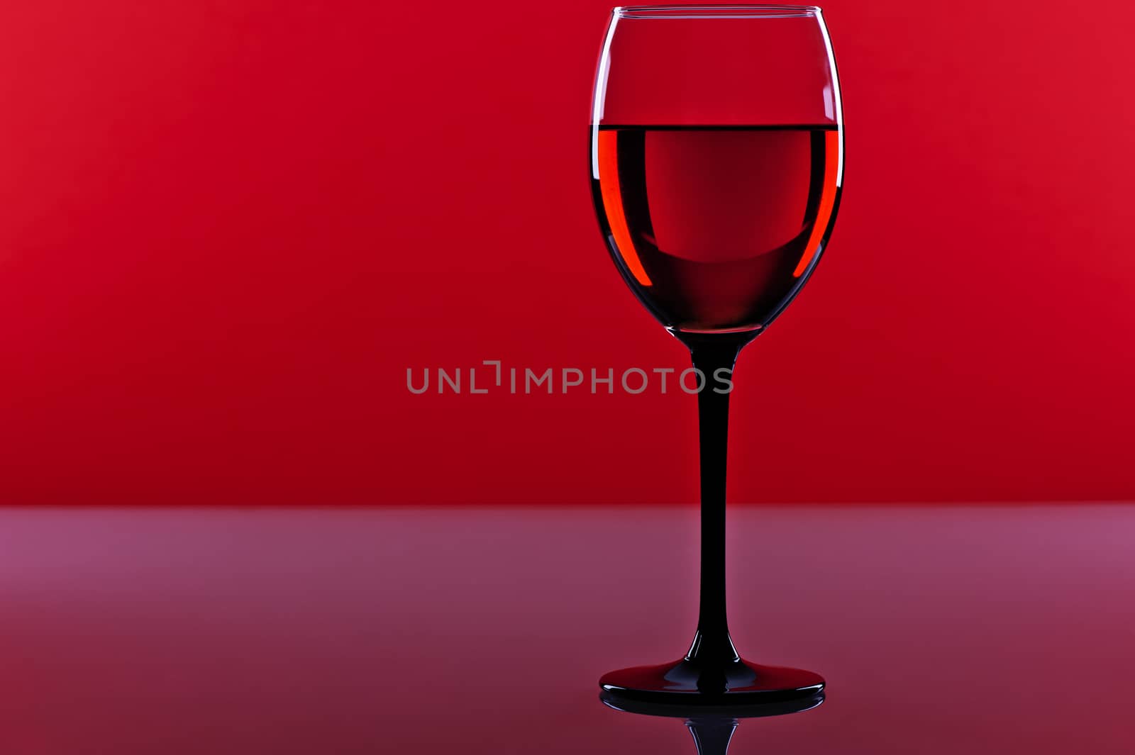 Glass of red french wine on a red background