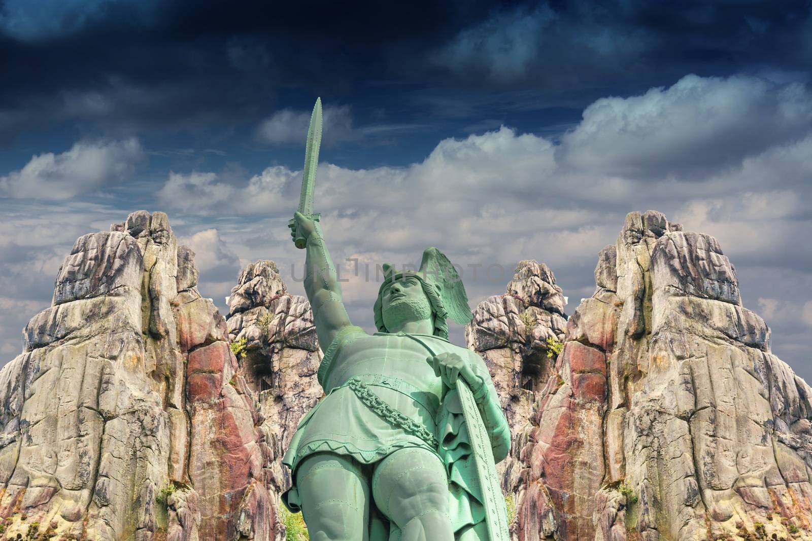 Curious and mysterious; Hermann Monument in the background, the Externsteine before dramatic sky.