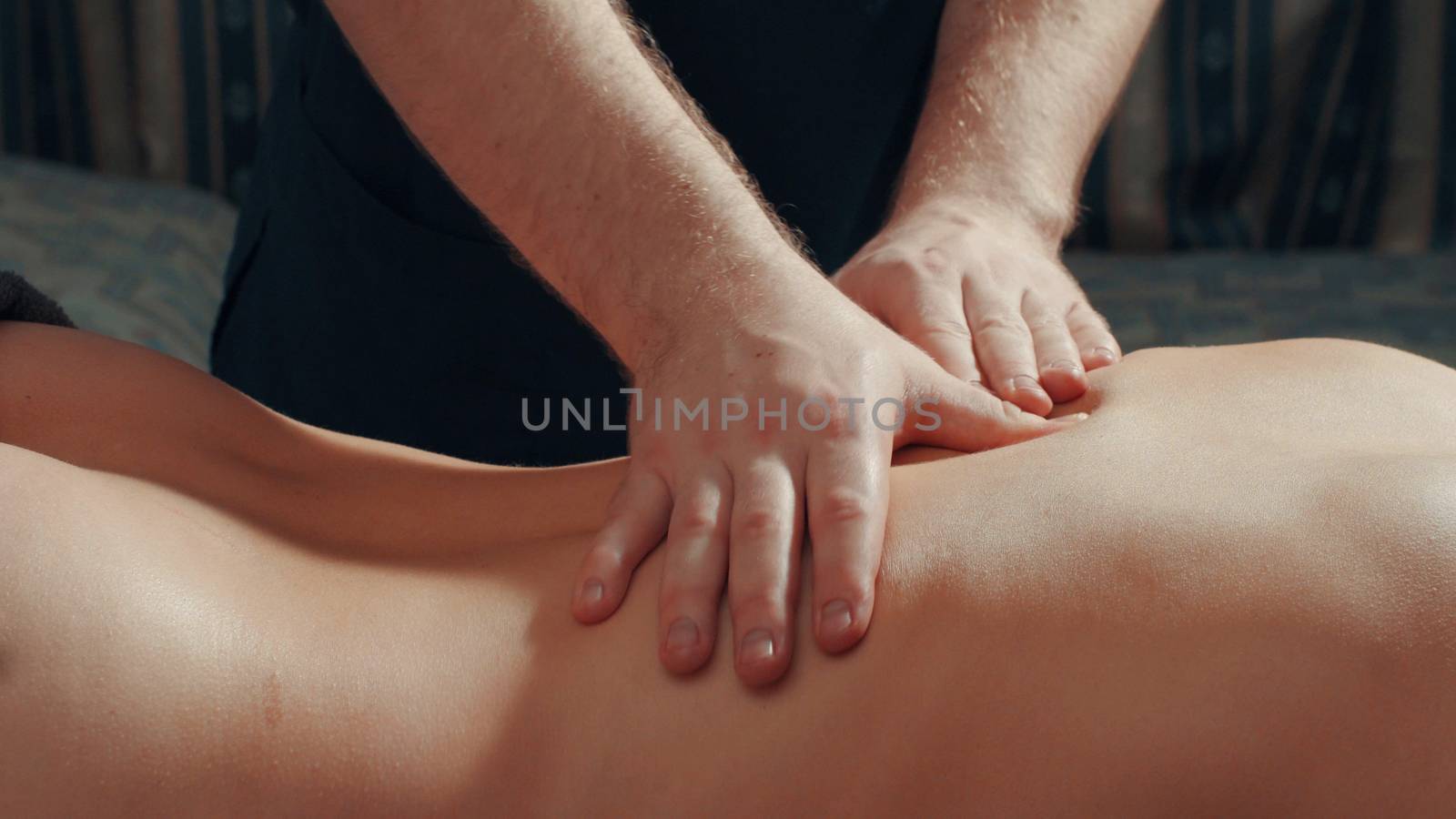 Man's hands massaging woman's back, close up