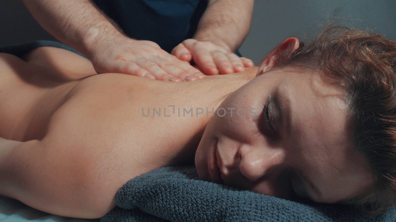 Man's hands massaging woman's back by Chudakov
