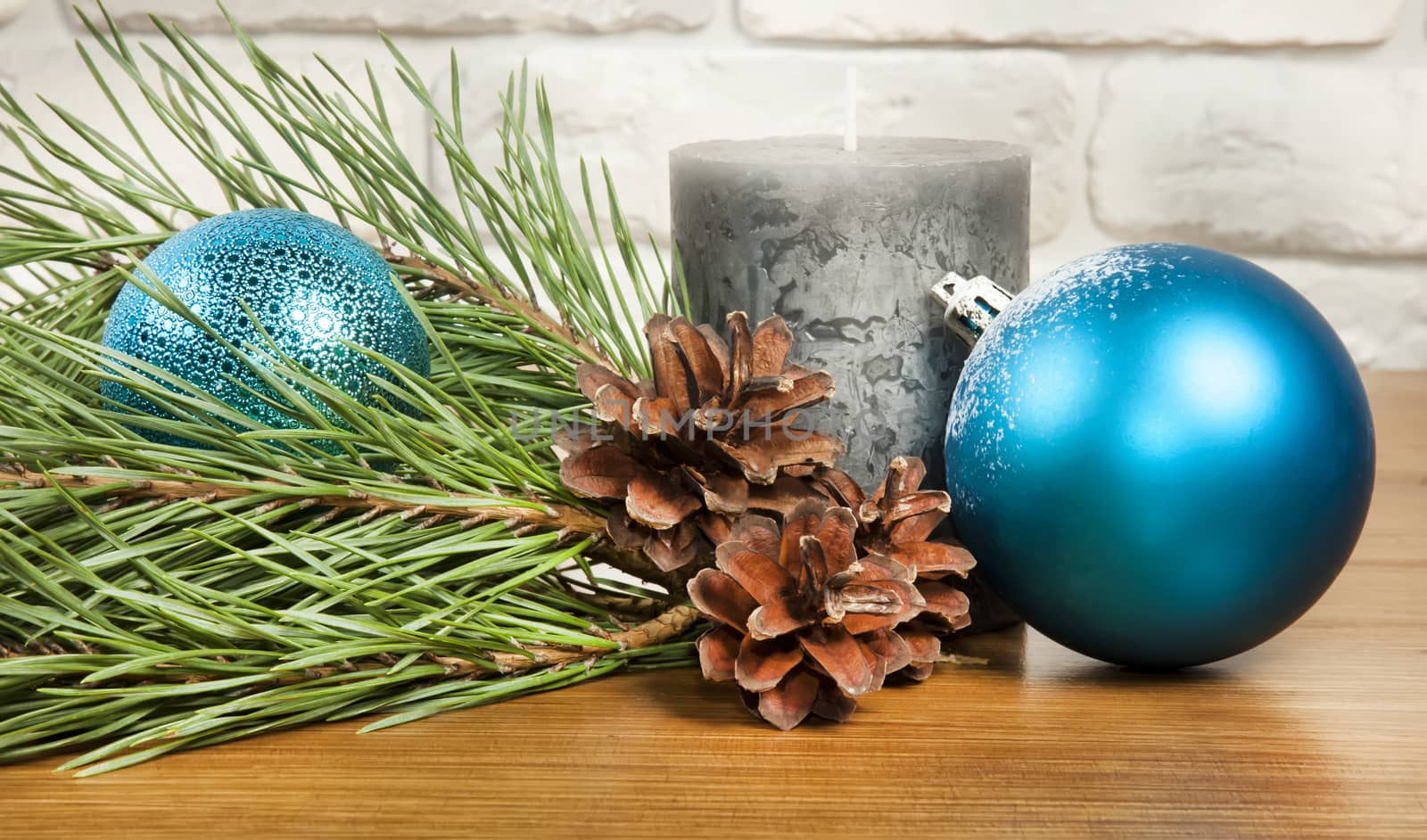 New Year and Christmas composition with fir cones and  candle on wooden and brick background