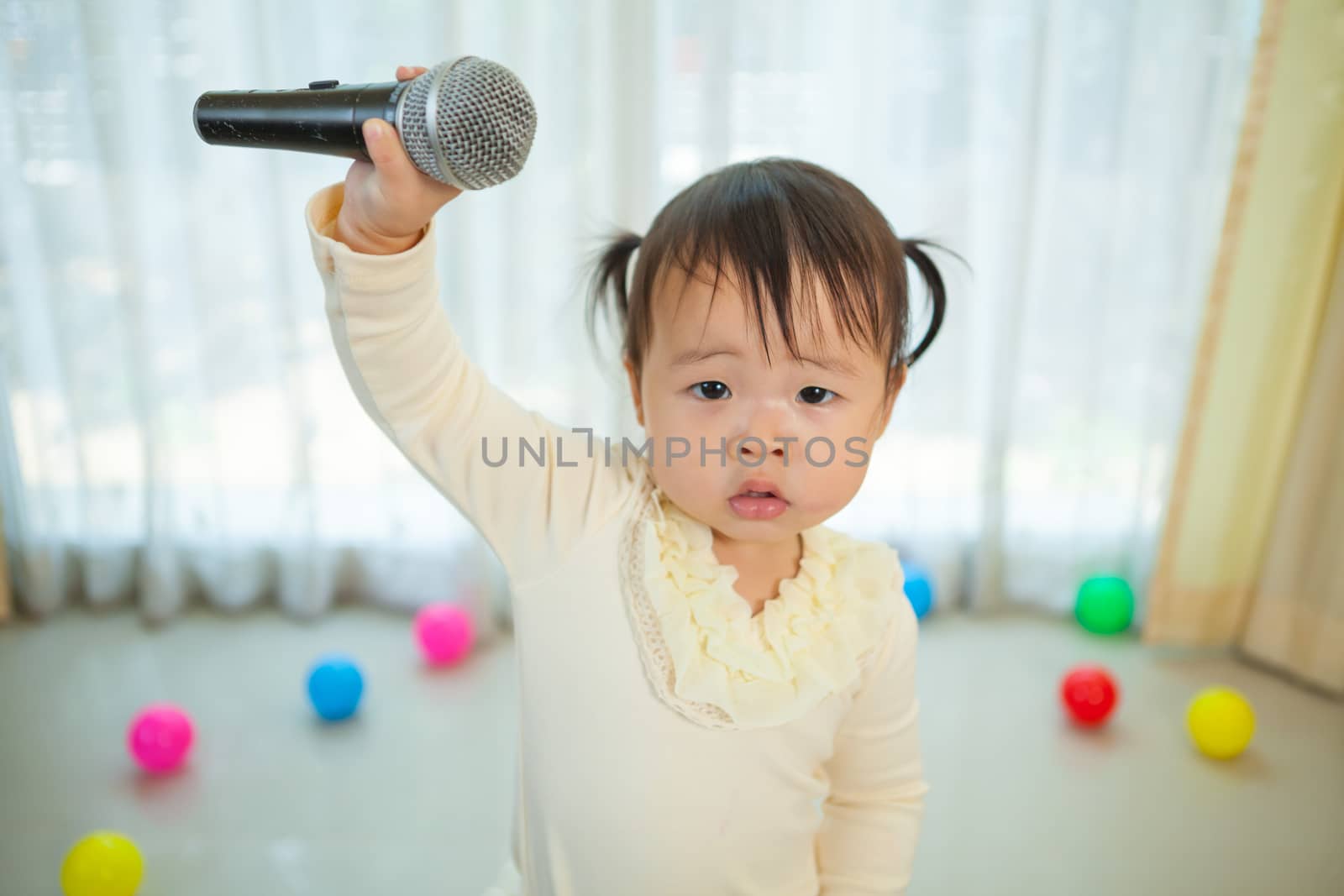little asian girl with microphone by witthaya