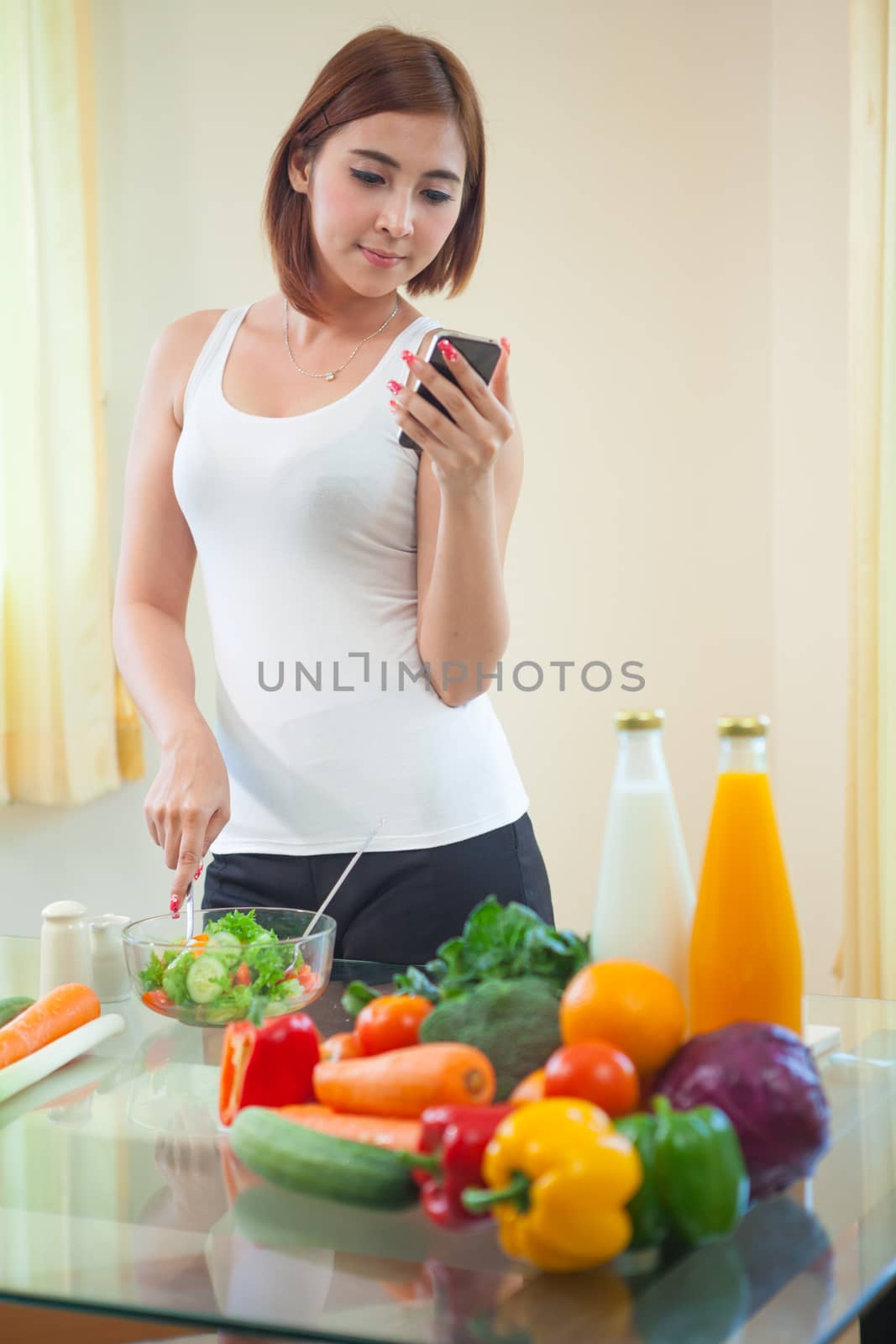 Young woman Following Recipe On mobile phone by witthaya