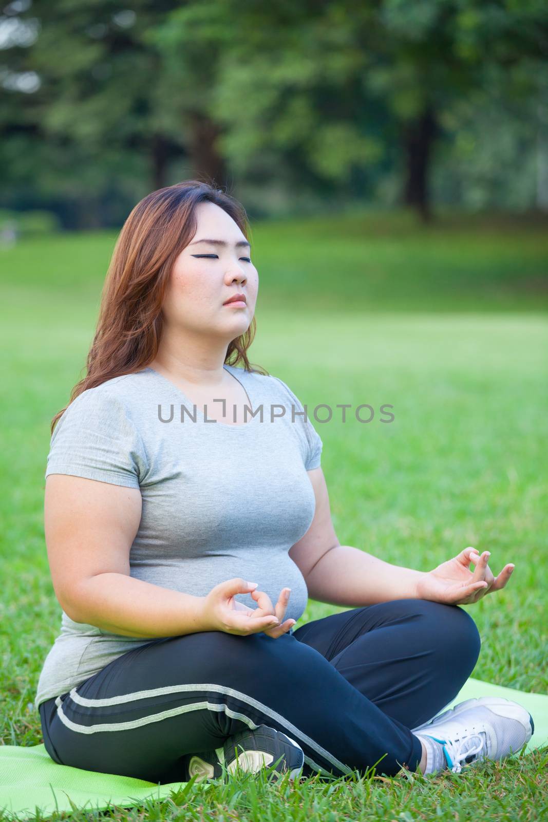 Plus size woman practicing yoga by witthaya