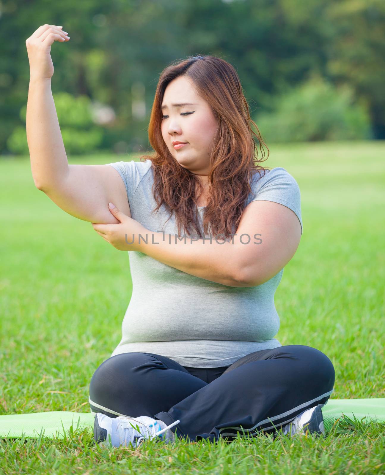 Young asian fat woman checking her arm fat