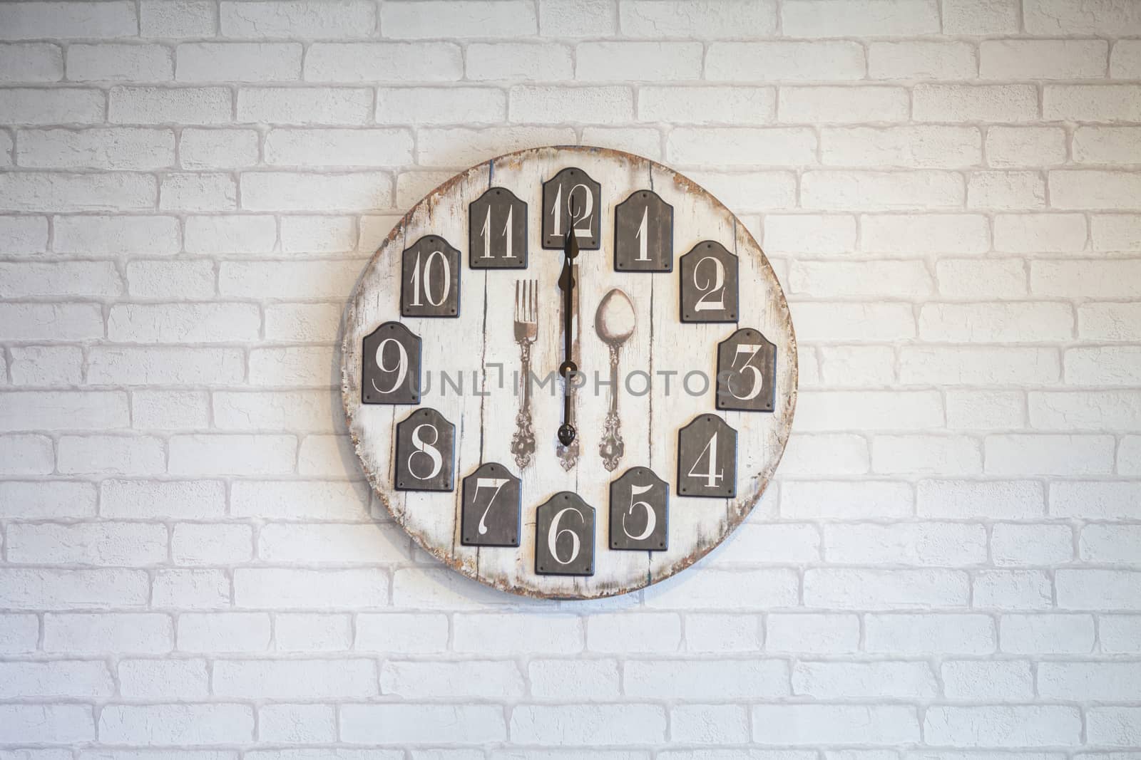Retro vintage wall clock on white brick wall