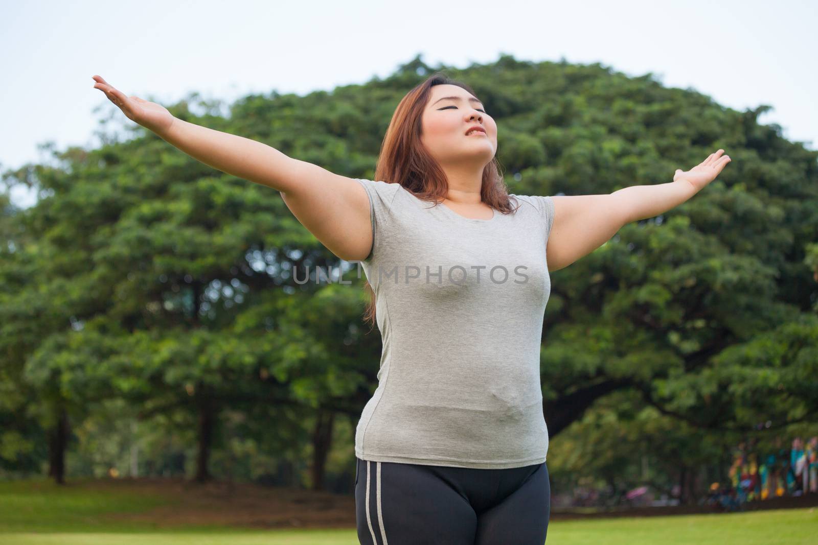 Happy fatty asian woman posing outdoor in a park