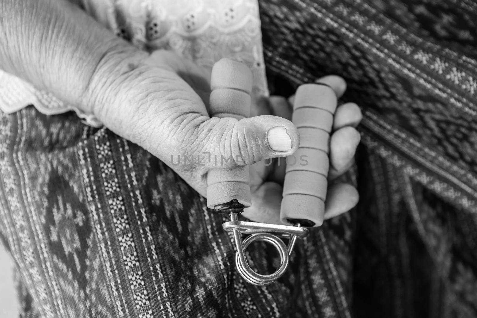 Black and white image of Senior asian woman exercise sport hand grip equipment