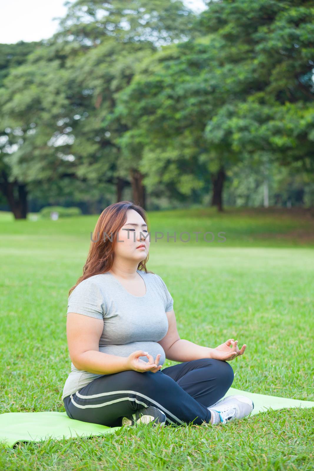 Plus size woman practicing yoga by witthaya