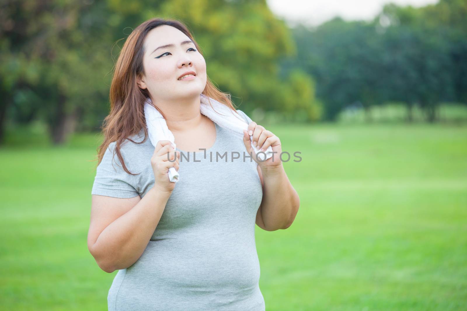 Happy fatty asian fit woman posing outdoor in a park