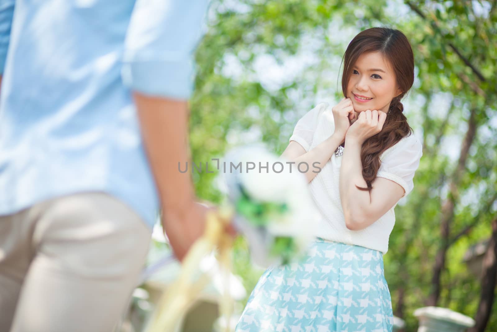 Man ready to give flowers to girlfriend in the park