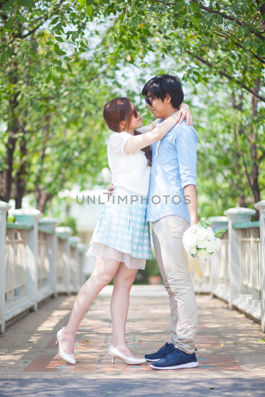 Loving asian couple under tree in the park