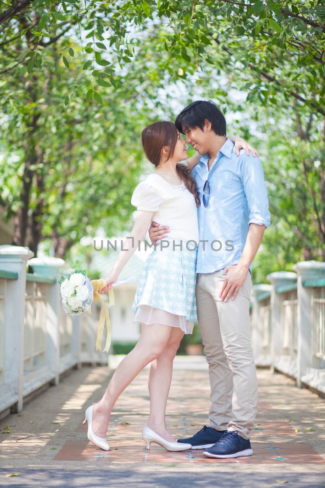 Loving asian couple under tree in the park